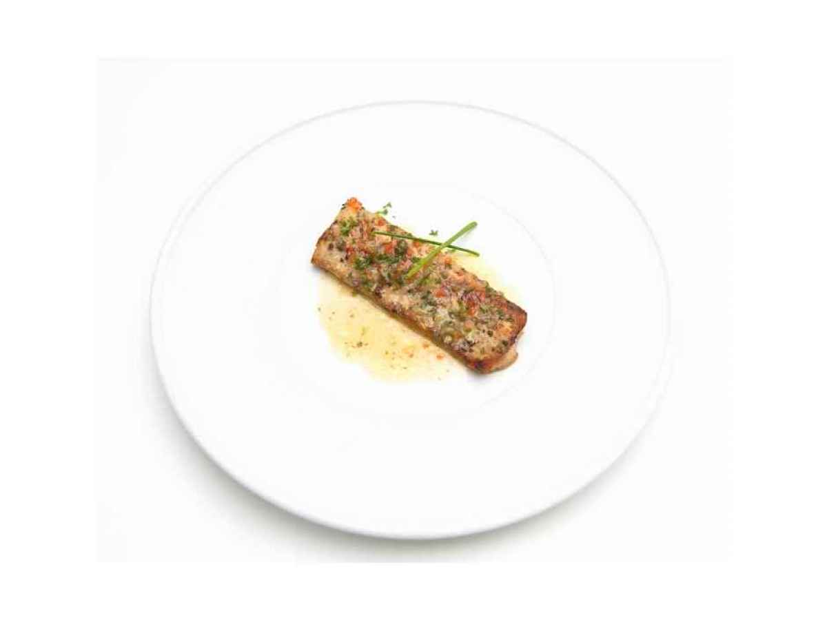 a piece of food on a plate Made with mahi, lemon juice, capers, garlic, and herbs. Gluten Free. Contains Dairy.