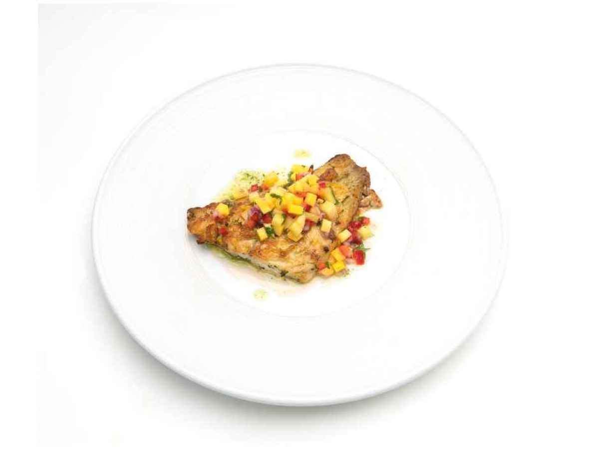 a plate of food Made with snapper, mango, pineapple, peppers, garlic, and herbs. Gluten Free.