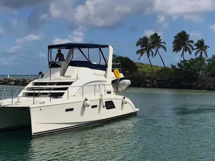 This 38 foot Aquila Boat Rental is anchored in tropical Melbourne, Florida waters, showcasing the spacious power catamaran design, flybridge seating, and calm Indian River Lagoon surroundings.