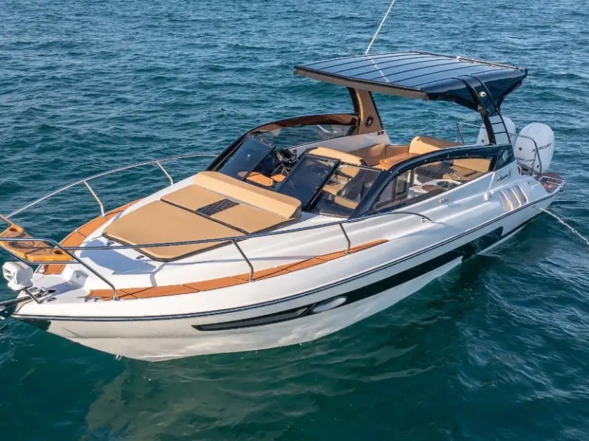 A 33 foot Hanover Boat Rental cruises across the waters of Palm Beach, showcasing sleek lines, a hardtop helm, and spacious bow seating during a luxury South Florida Boat Rental.
