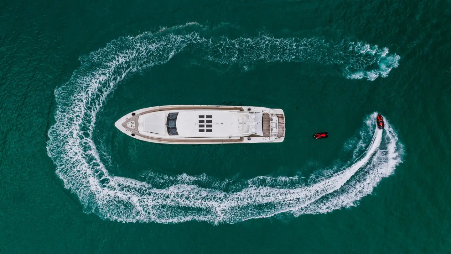 Overhead drone shot of 101′ Leopard Miami with jetski circling