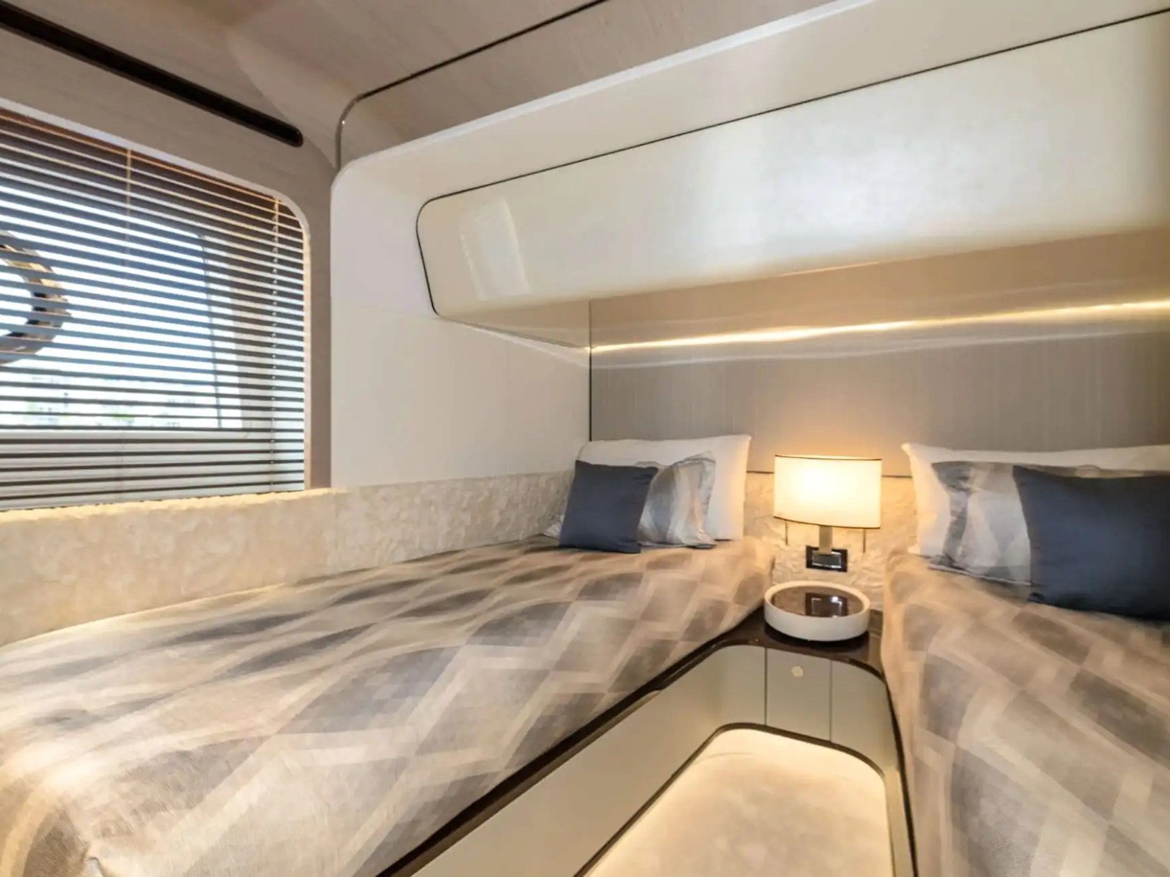 Comfortable twin guest cabin aboard the 88 Azimut Yacht Charter featuring two single berths, designer bedding, ambient lighting, and modern accommodations in Nassau, Bahamas.