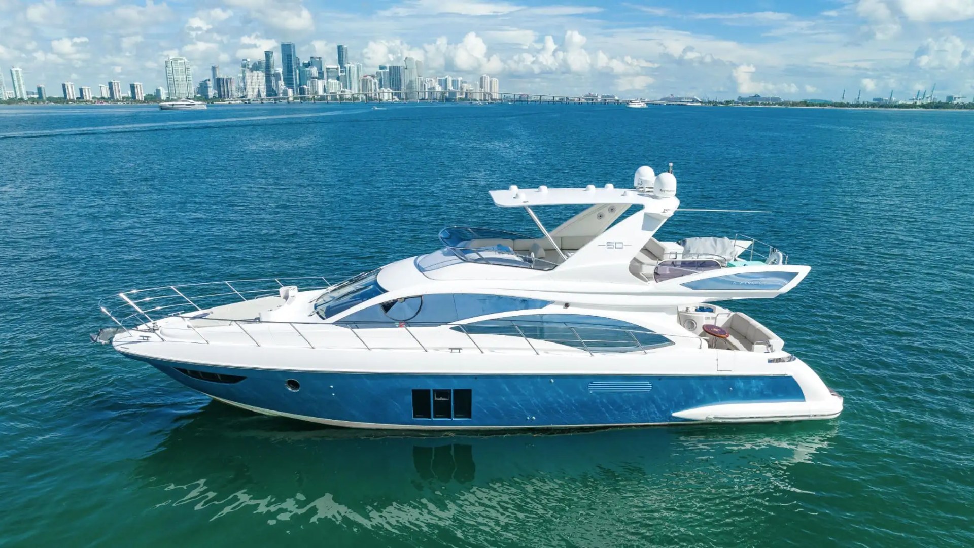 62′ Azimut yacht side profile cruising near Miami skyline