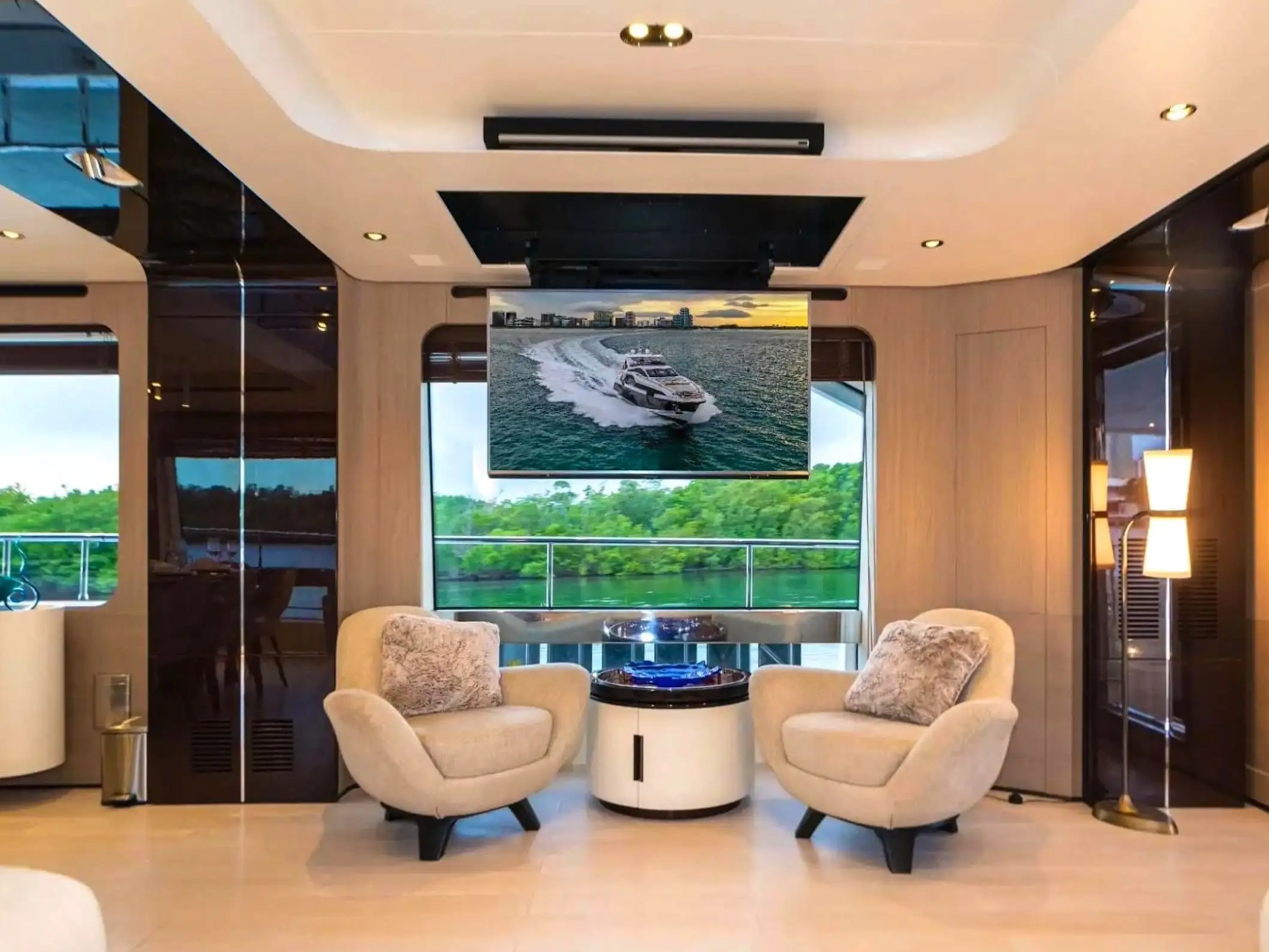 Elegant main salon aboard the 88 Azimut Yacht Charter featuring designer lounge seating, panoramic windows, entertainment system, and luxury interior accommodations in Nassau, Bahamas.