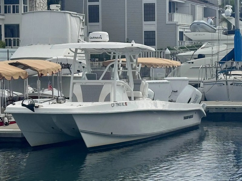 26' PowerCat Boat Rental docked at a Marathon marina featuring a center console helm, twin-hull catamaran design, and Florida Keys waterfront setting.