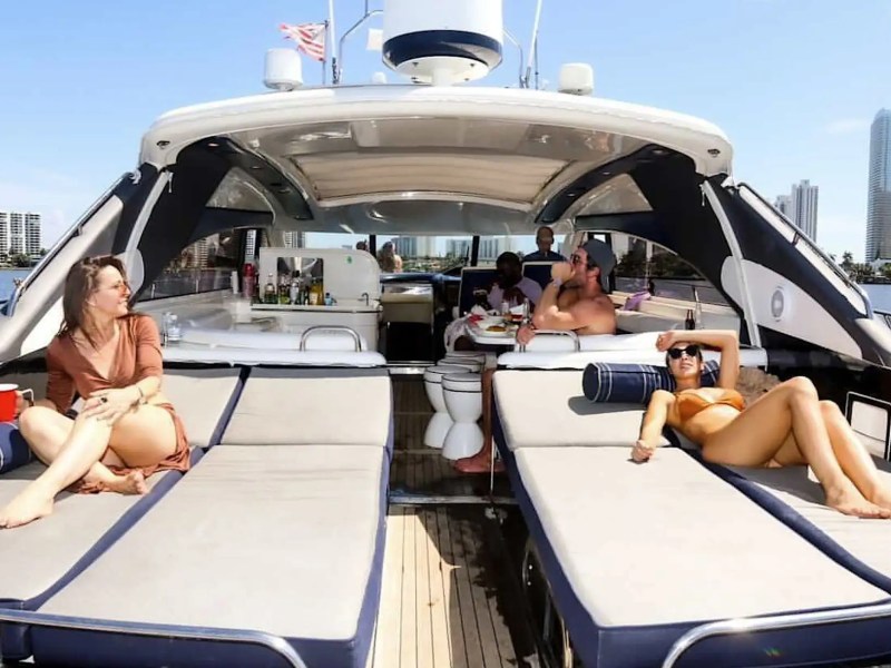 70' Princess yacht charter Miami Beach guests relaxing on luxury sunbeds