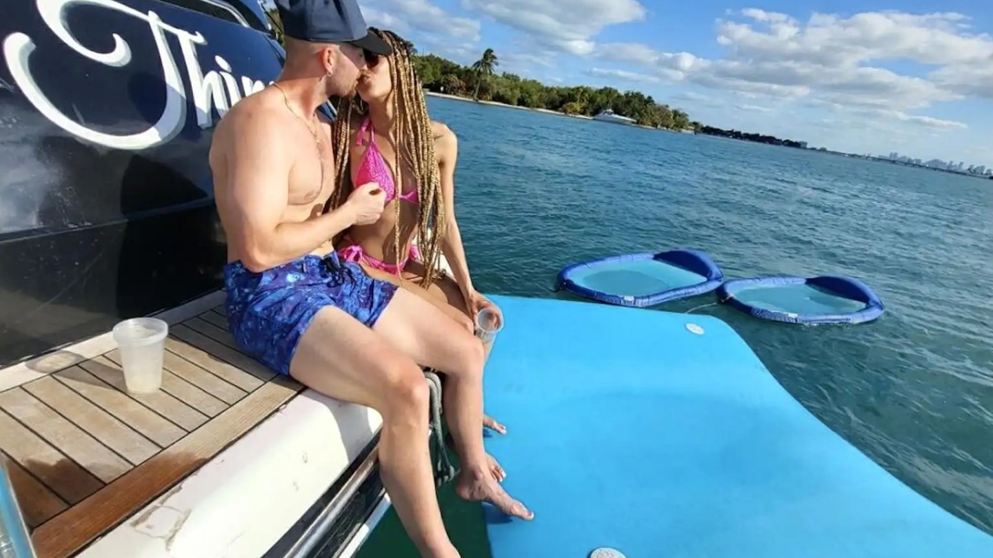 Couple relaxing on swim platform during 70' Princess yacht charter Miami Beach