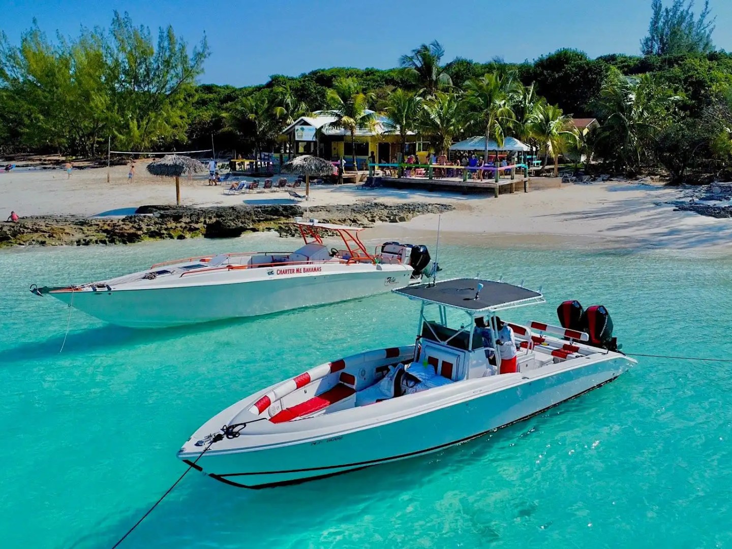 35' Marlin Boat Rental anchored in crystal-clear turquoise waters near a tropical Nassau beach, showcasing Bahamas island-hopping and coastal adventure experiences.