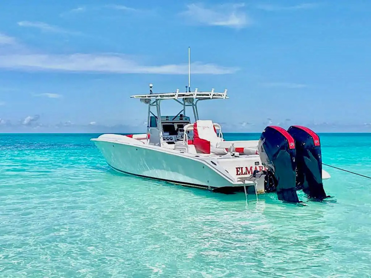35' Marlin Boat Rental anchored in shallow turquoise waters near Nassau, Bahamas, showcasing twin outboards, center console design, and pristine tropical sandbar conditions.