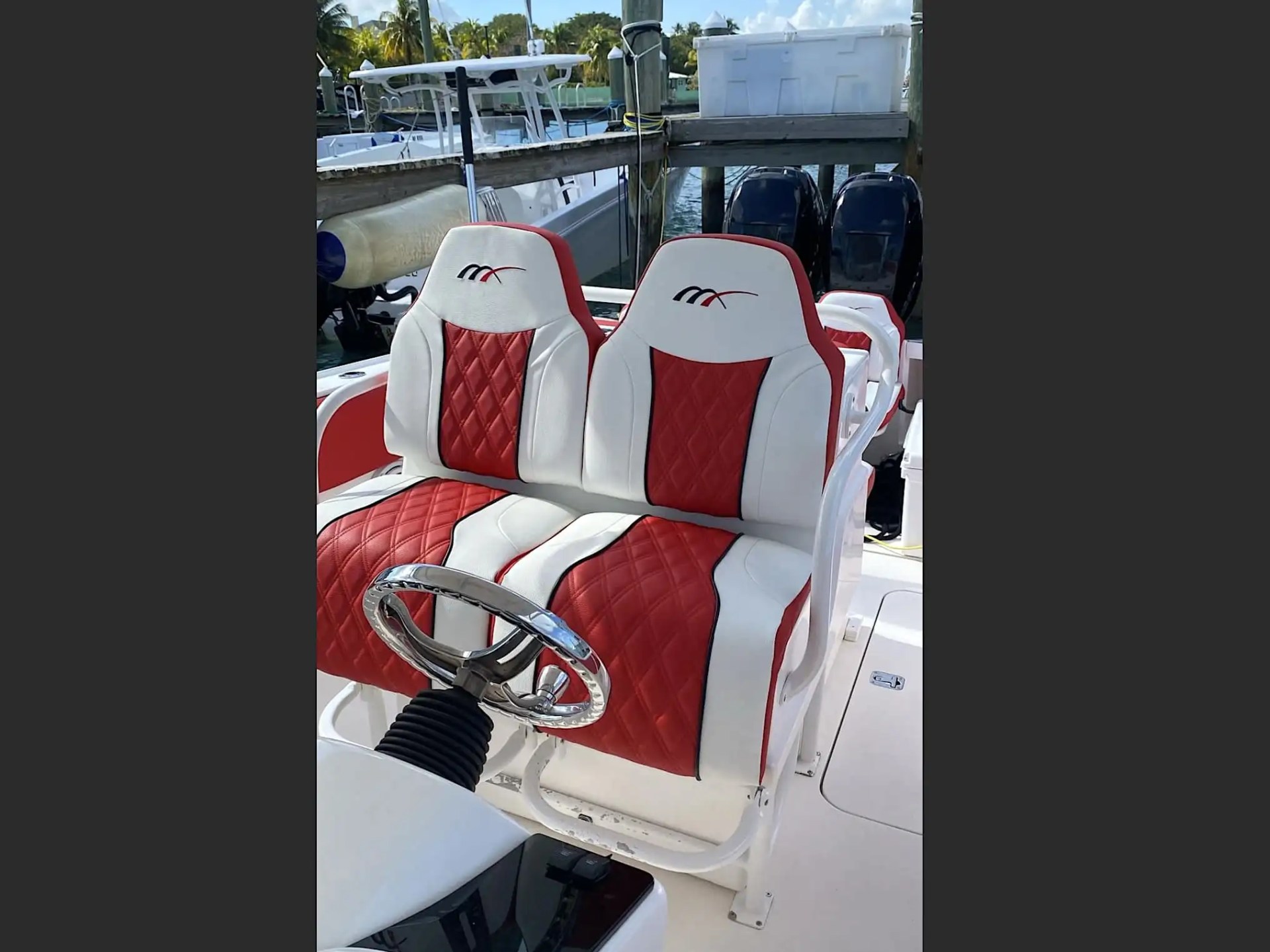 35' Marlin Boat Rental helm seating with premium red-and-white diamond-stitched captain chairs at a Nassau Bahamas marina, showcasing luxury center console comfort and performance-focused design.