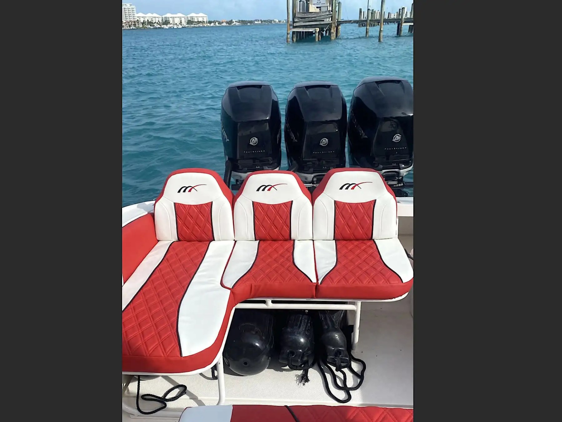 35' Marlin Boat Rental aft lounge seating with custom red-and-white diamond-stitched upholstery and triple Mercury outboards in Nassau, Bahamas, showcasing premium comfort and high-performance boating.