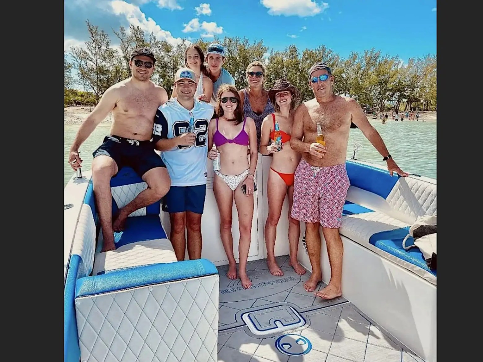 Guests enjoying a 35' Marlin Boat Rental anchored near a tropical sandbar in Nassau, Bahamas, featuring spacious seating, socializing, and crystal-clear island waters.