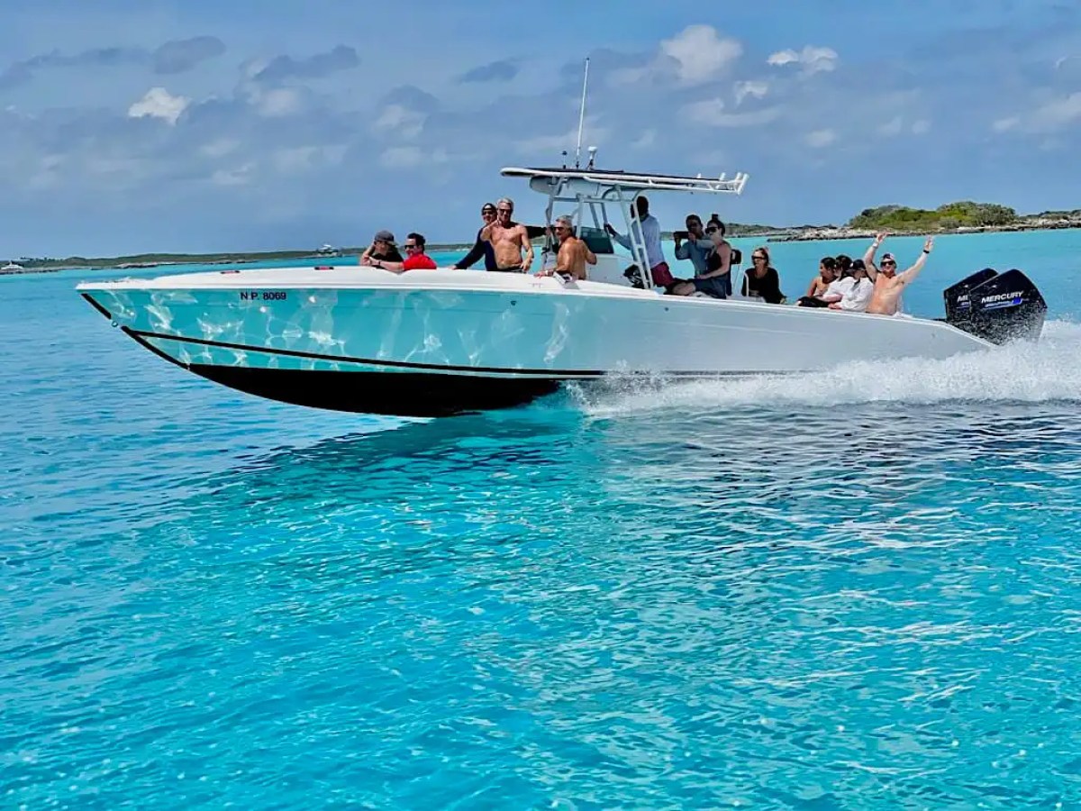 Guests enjoying a high-speed 35' Marlin Boat Rental across crystal-clear turquoise waters in Nassau, Bahamas, showcasing island hopping adventures and tropical sightseeing.
