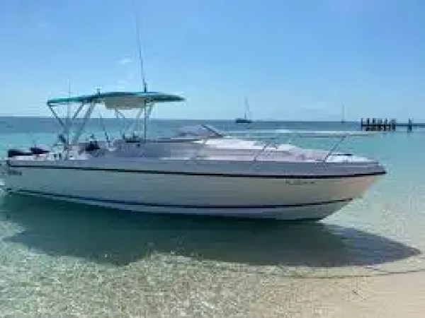 37' Intrepid center console boat rental anchored in shallow turquoise water near Pompano Beach, Florida with a T-top shade and spacious bow seating visible along the South Florida coastline.