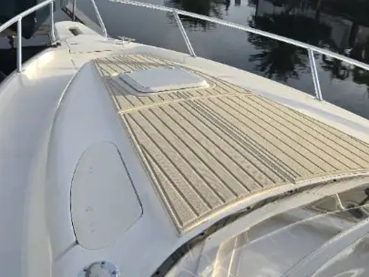 37 foot Intrepid center console boat rental featuring a spacious teak-style bow lounge area docked along the waterways of Pompano Beach, Florida with stainless rails and open sunbathing space visible.