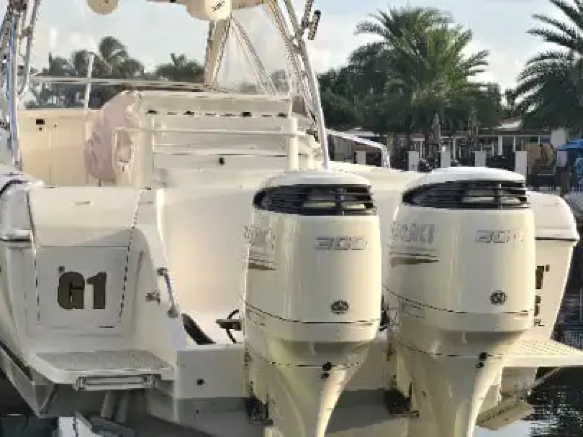 37 foot Intrepid center console boat rental docked in Pompano Beach, Florida featuring twin 300 horsepower outboard engines, swim platforms, and an open aft deck along the South Florida waterfront.