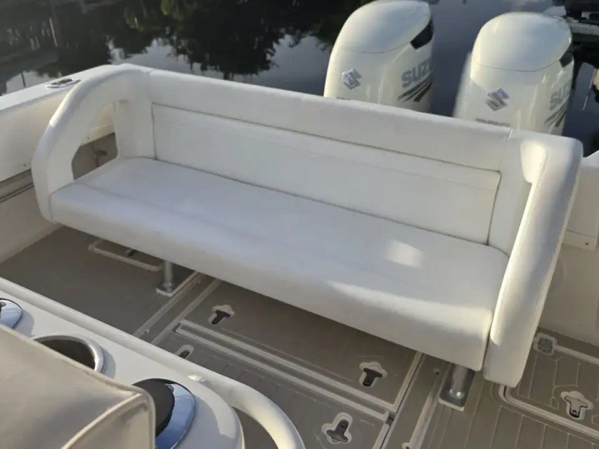 37 foot Intrepid center console boat rental featuring a cushioned aft bench seat in Pompano Beach, Florida with twin Suzuki outboard engines and an open cockpit layout visible.