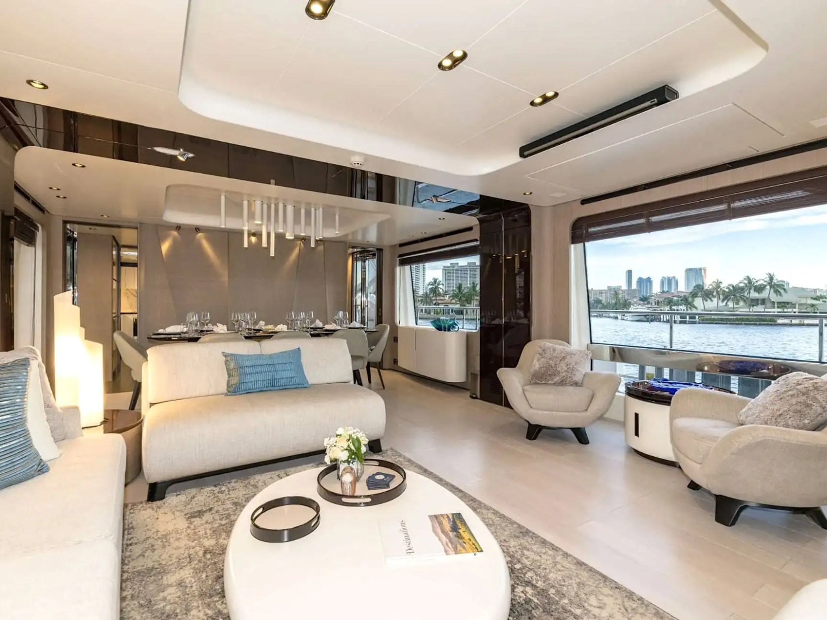 88 Azimut Yacht Charter main salon featuring modern lounge seating, formal dining area, panoramic waterfront windows, and elegant contemporary interior design in Nassau