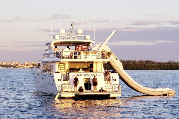 Giant inflatable slide from the top deck of this charter yacht, the 103′ Johnson Key Biscayne