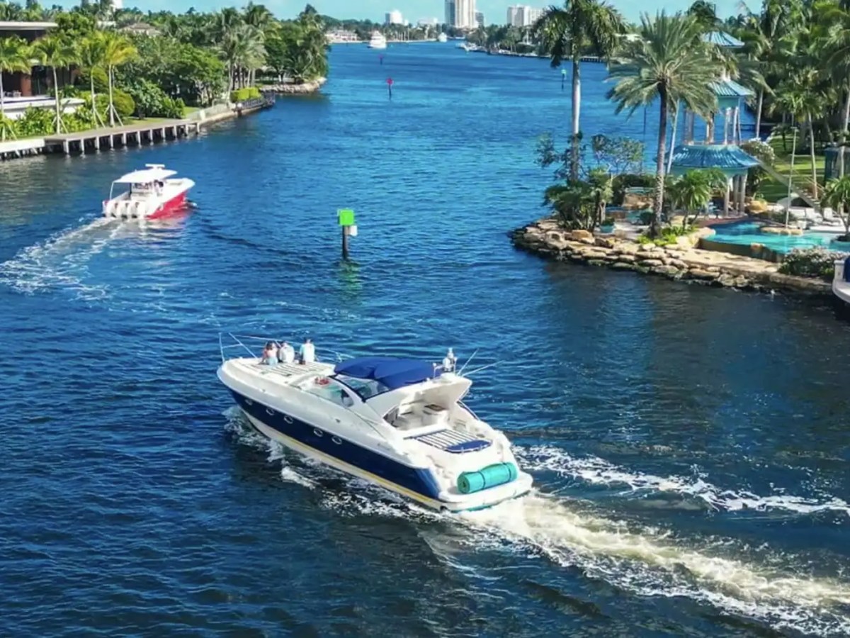 50′ Fairline yacht cruising through Fort Lauderdale’s Intracoastal Waterway surrounded by waterfront estates, palm trees, and luxury South Florida scenery.