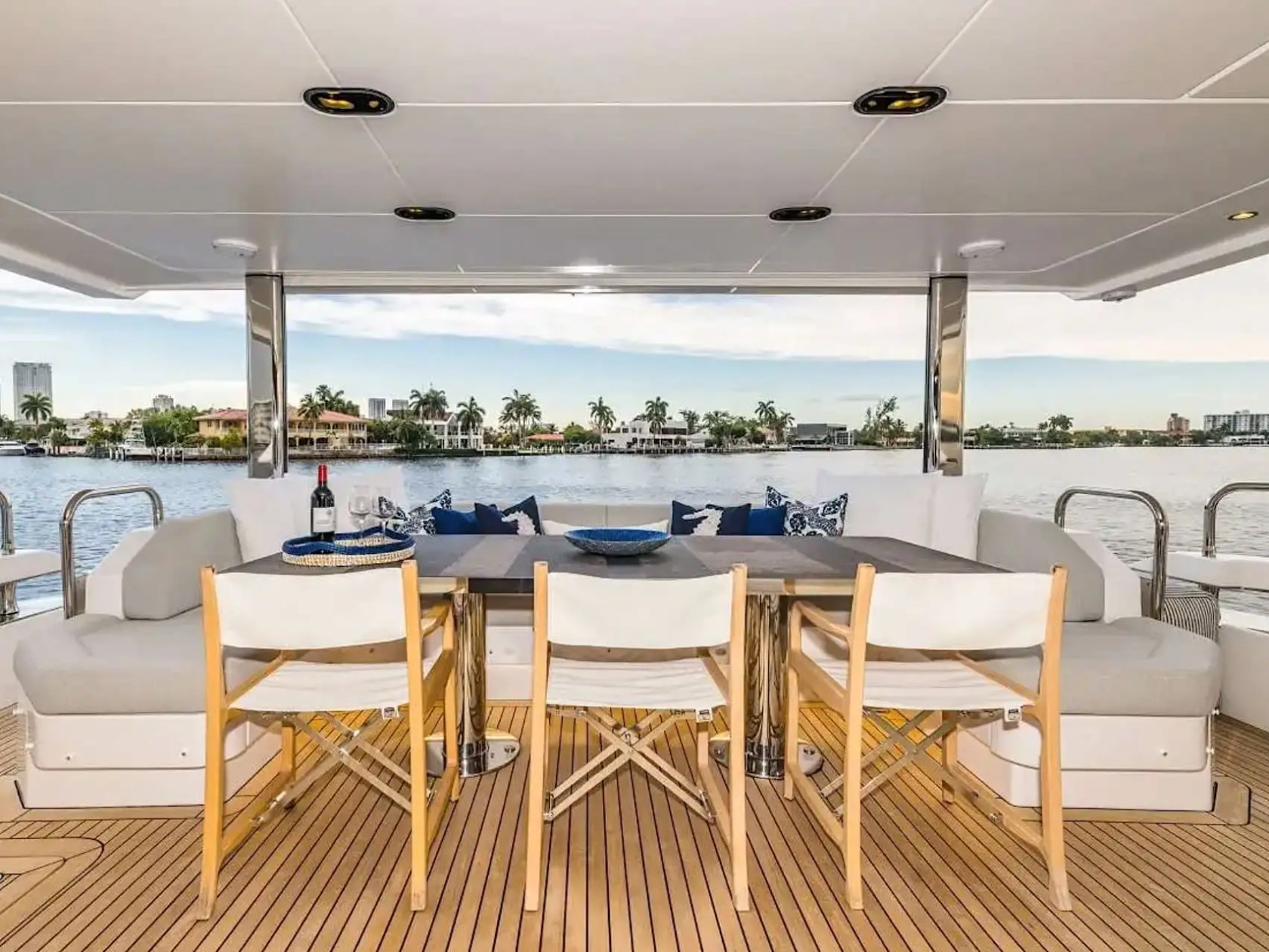 88 Azimut Yacht Charter aft deck dining area with cushioned seating, teak decking, waterfront views, and open-air entertaining space in Nassau Bahamas