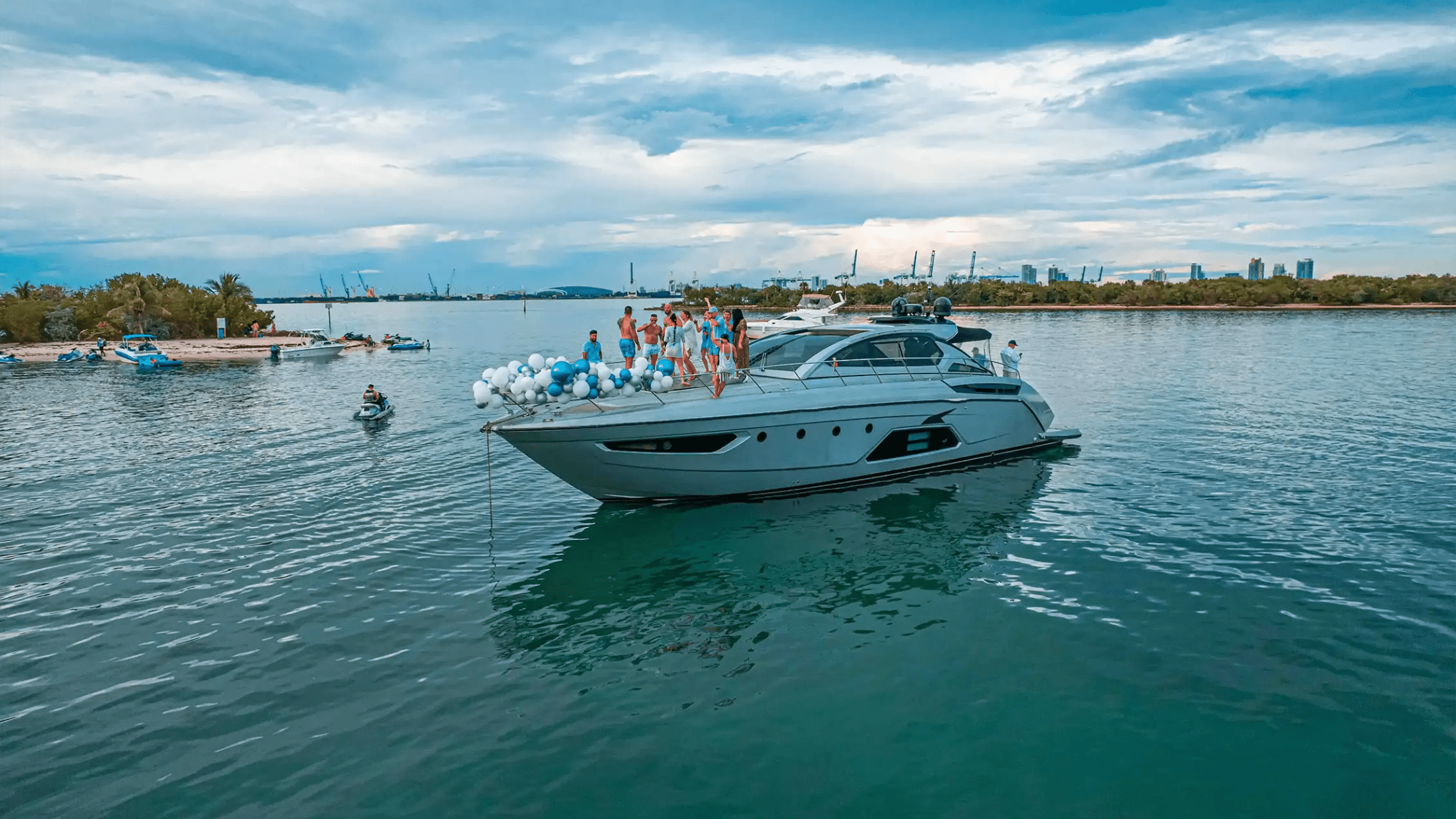 Friends celebrating at anchor on bow of 64′ Atlantis Miami