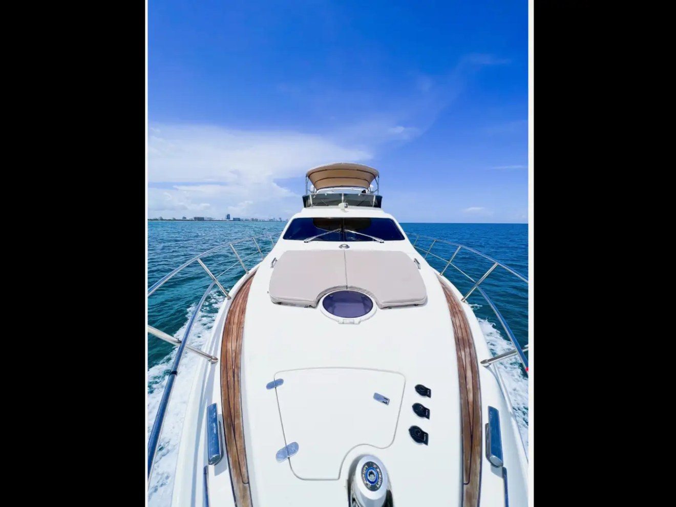 50 foot Azimut Yacht Charter bow sun pad cruising offshore near Hollywood Beach Florida with open Atlantic Ocean views, teak walkways, and luxury South Florida yachting scenery.