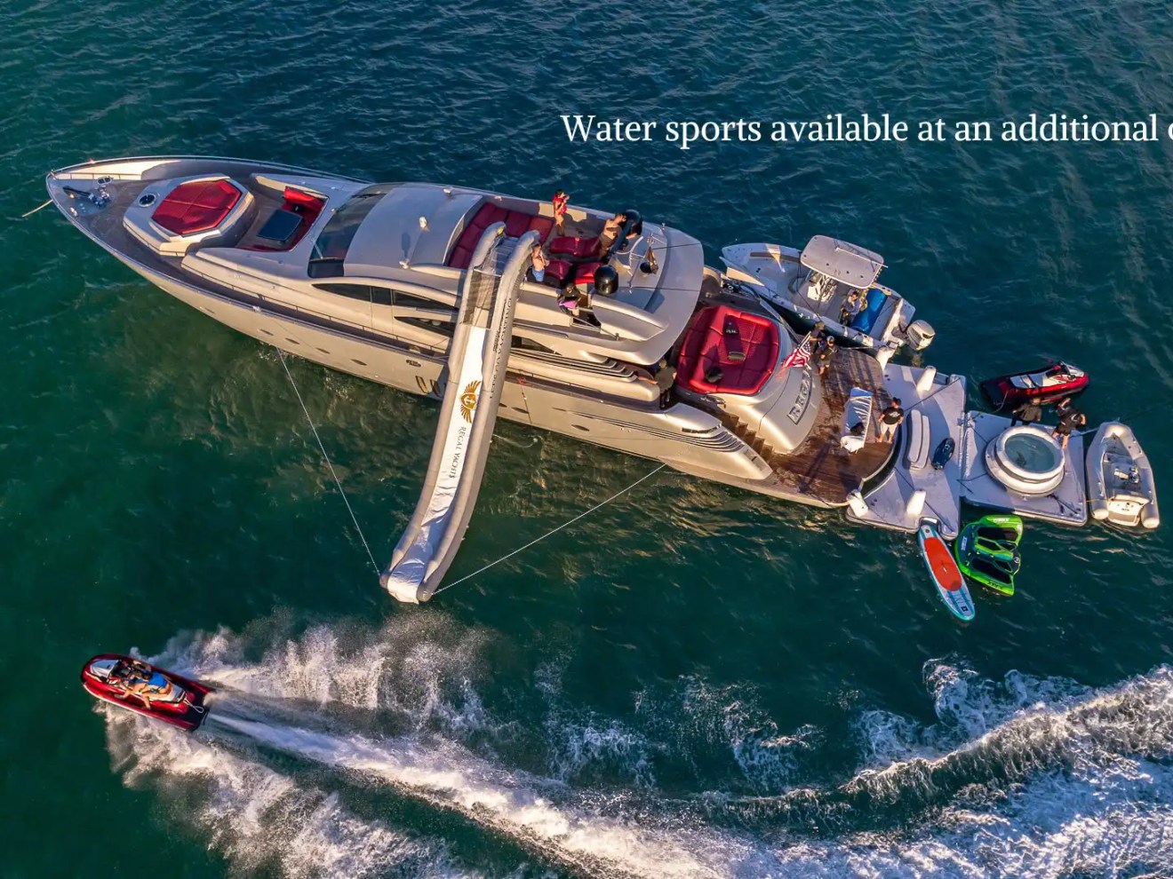 90 Pershing Yacht Charter aerial view anchored in Miami waters with inflatable slide, jet skis, paddleboard, swim platform, and guests enjoying South Florida boating
