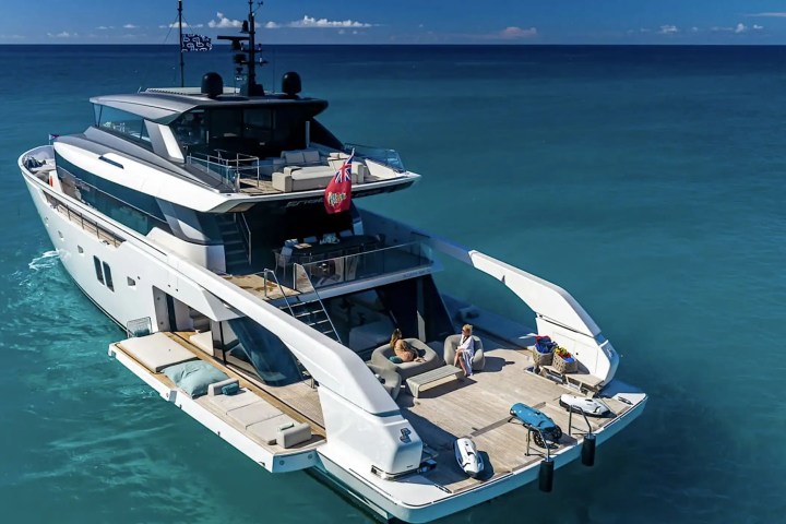 Luxury yacht on the ocean with people relaxing on the deck.
