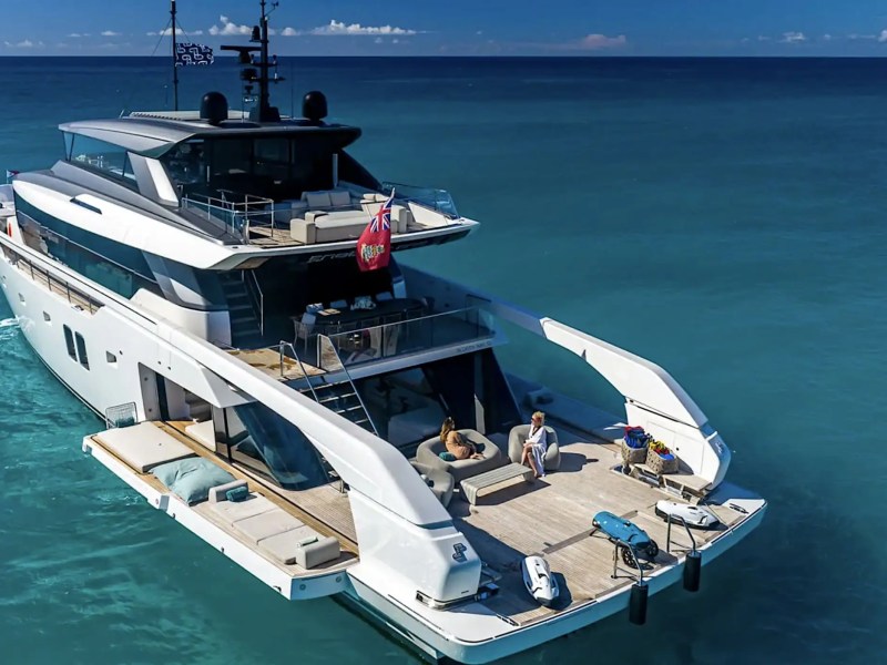 Luxury yacht on the ocean with people relaxing on the deck.