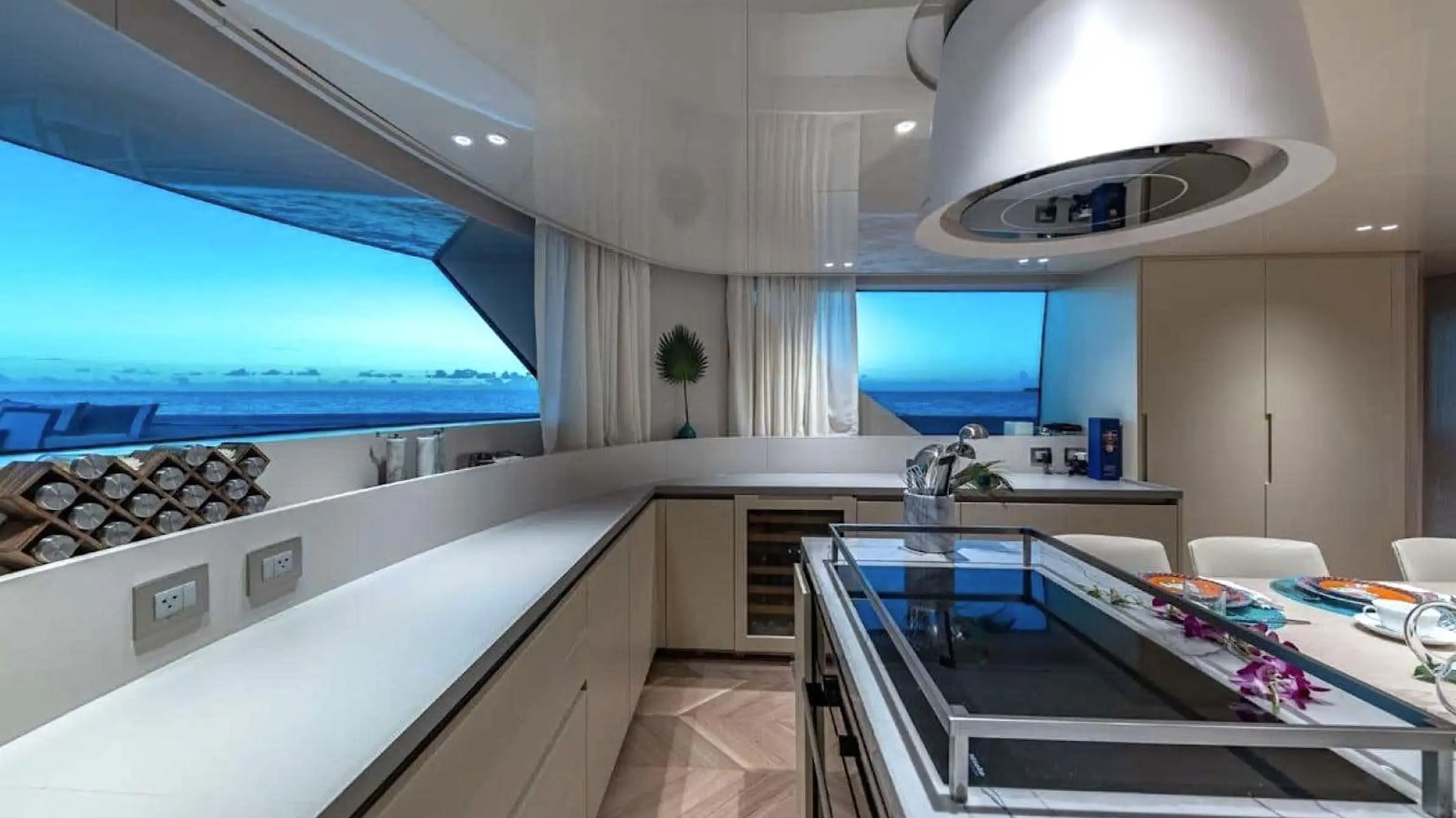 Modern yacht kitchen with large windows, sleek cabinets, and a central island.