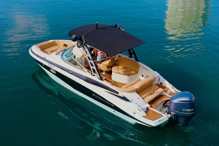 Motorboat with canopy on clear blue water, view from above.