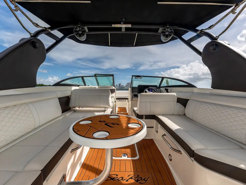 29' Sea Ray Boat Rental cockpit lounge featuring wraparound seating, Sea Ray table, premium upholstery, hardtop shade, and Miami Beach waterfront cruising comfort