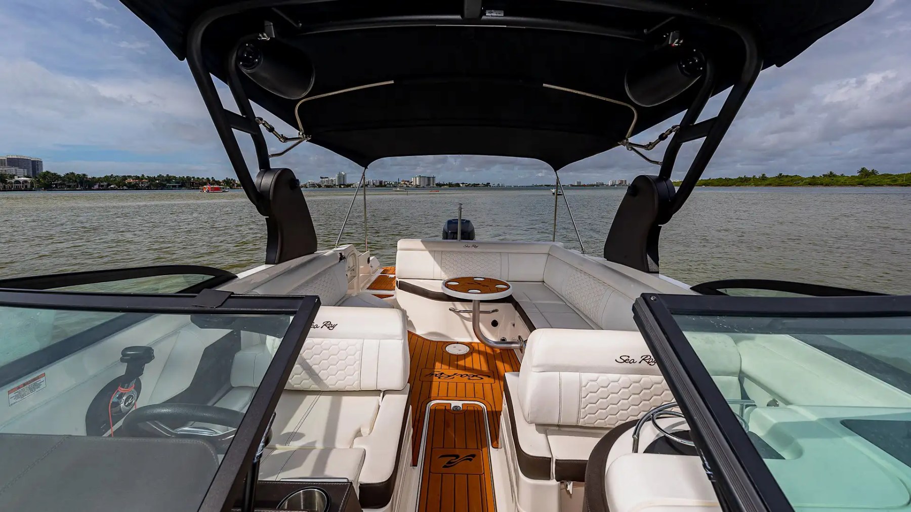 29' Sea Ray Boat Rental featuring premium cockpit seating, teak-style flooring, hardtop shade, and social lounge layout cruising near Miami Beach waterways