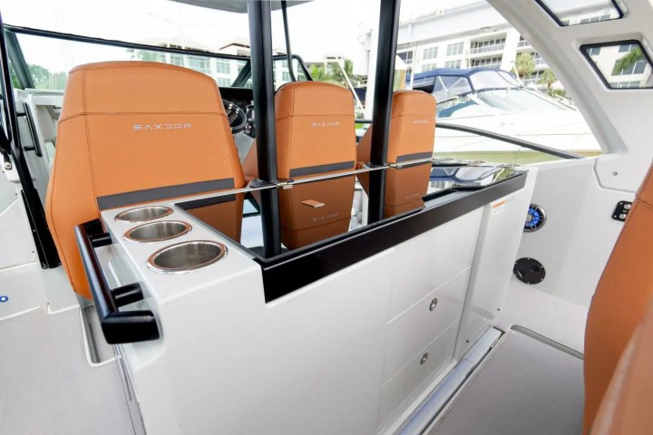 Boat interior with orange seats, cup holders, and a console.