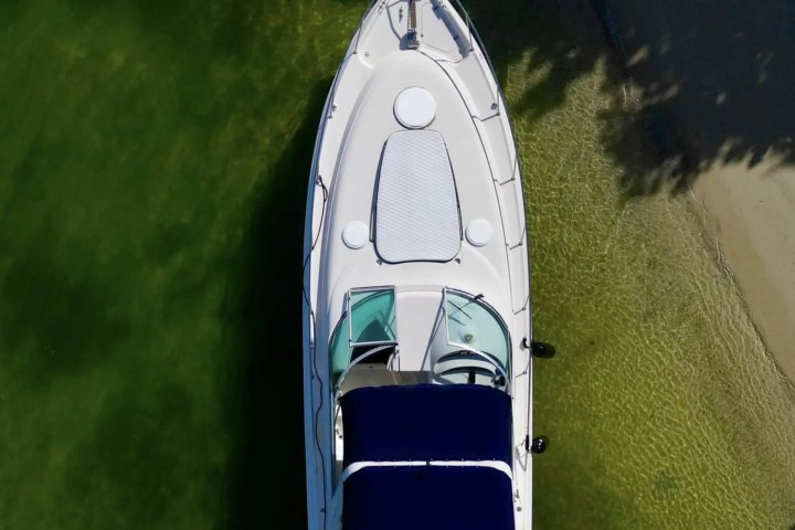 Shoreline reflection on hull of 37′ Monterey Miami