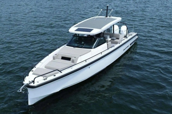 White speedboat with covered seating cruising on open water.