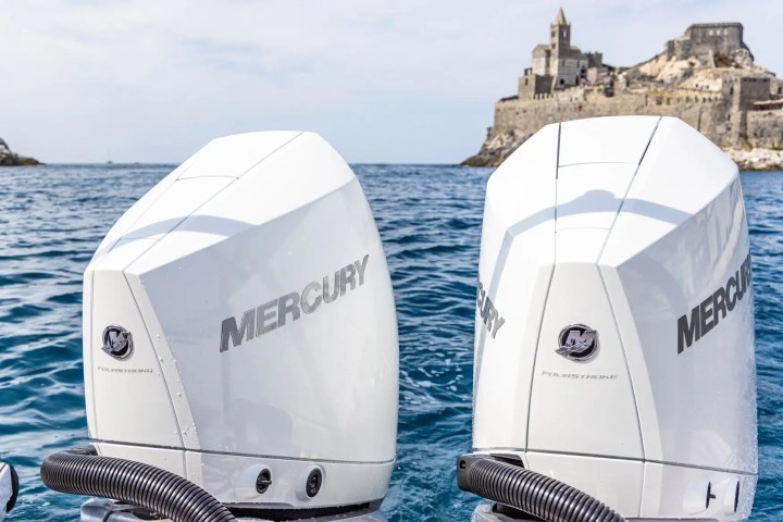 Two Mercury boat engines with a seaside castle in the background.