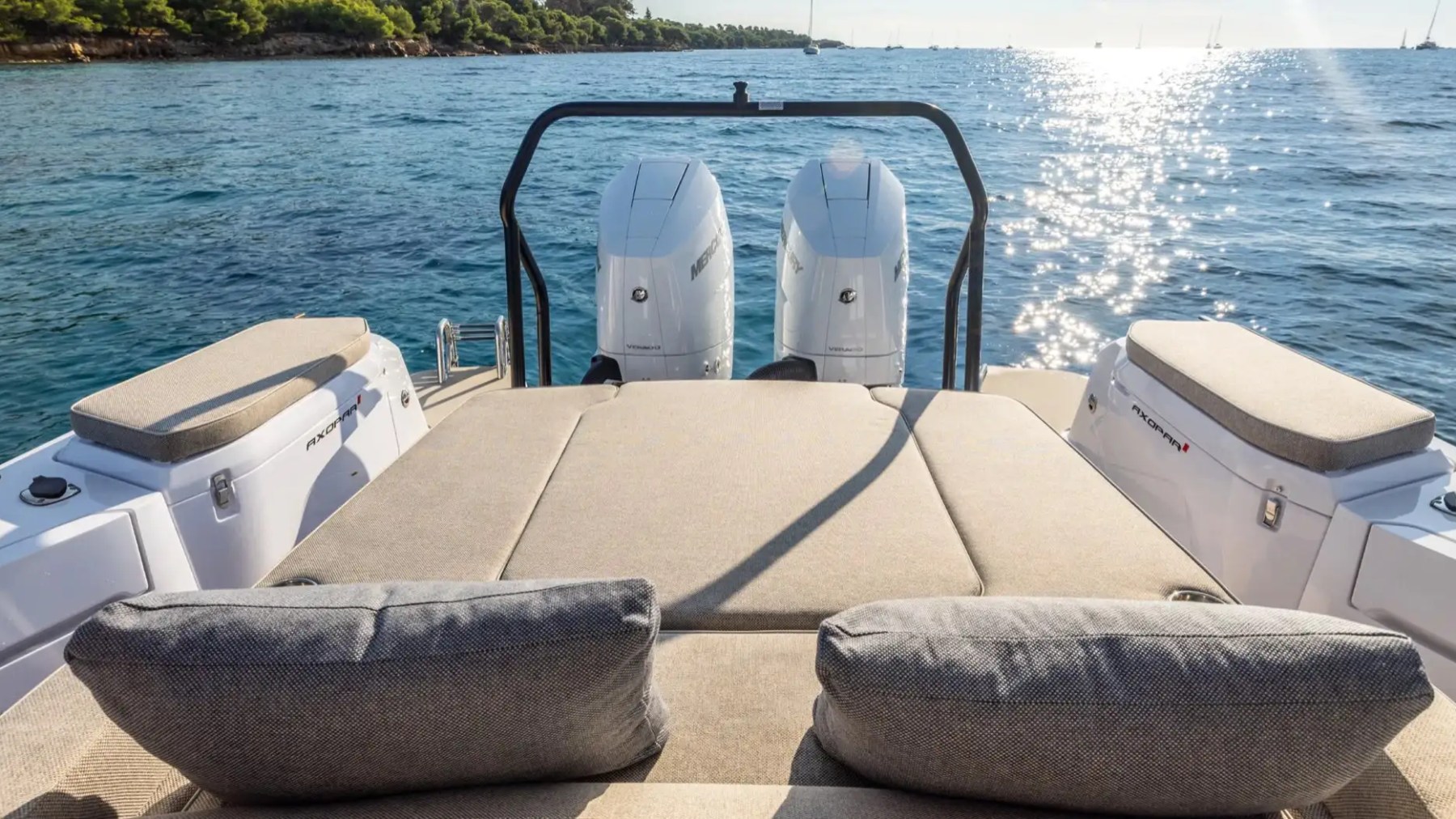 Boat deck with cushioned seats overlooking a sunny ocean view.
