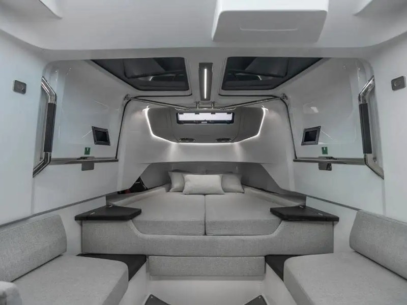 Interior of a modern yacht cabin with gray seating and sleek design.