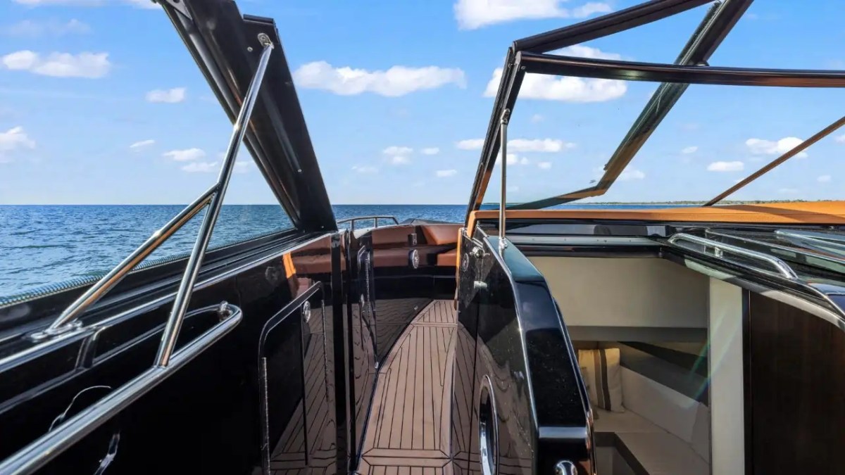 View from a luxury yacht deck with open canopy, facing the sea and blue sky.