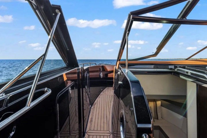 View from a luxury yacht deck with open canopy, facing the sea and blue sky.