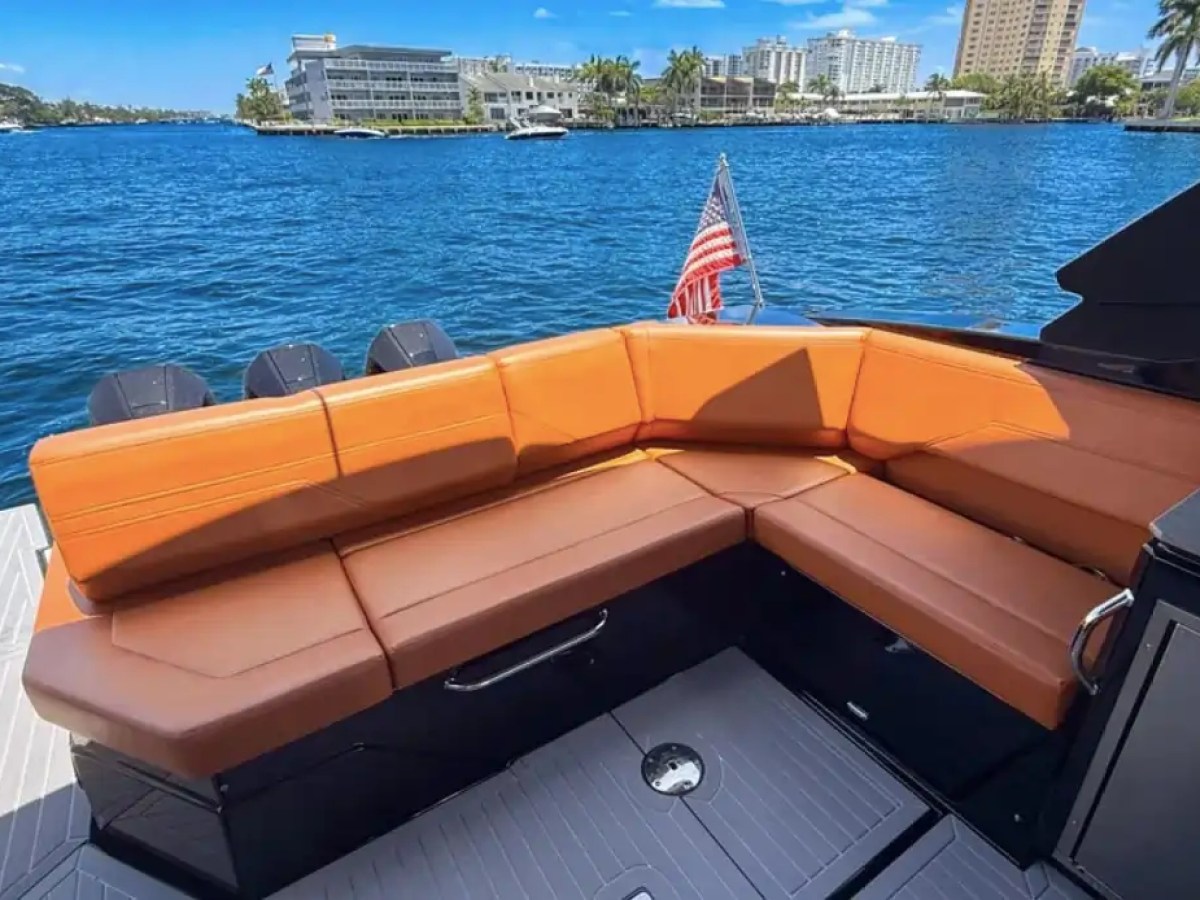 This 38 foot Cruisers Boat Rental features a spacious aft lounge with wraparound tan seating, swim platform access, and Naples waterfront views along the Intracoastal Waterway.