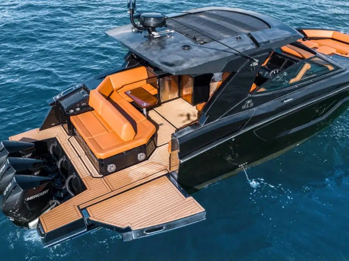 This 38 foot Cruisers Boat Rental is shown from an aerial perspective featuring the aft lounge, expansive swim platform, triple outboard engines, and open-air deck space on Naples waterways.