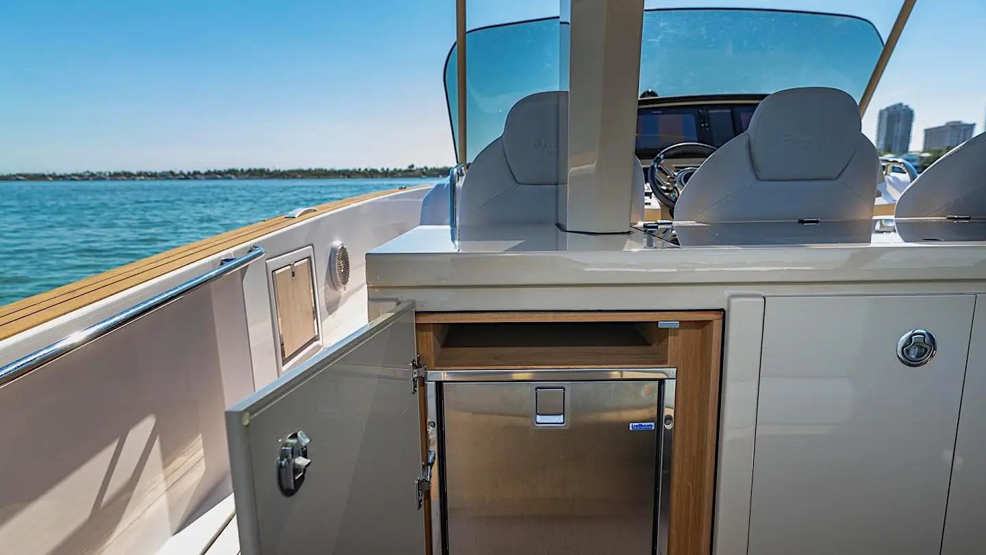Boat cockpit with open cabinet and mini fridge on 38′ Pardo Miami Beach