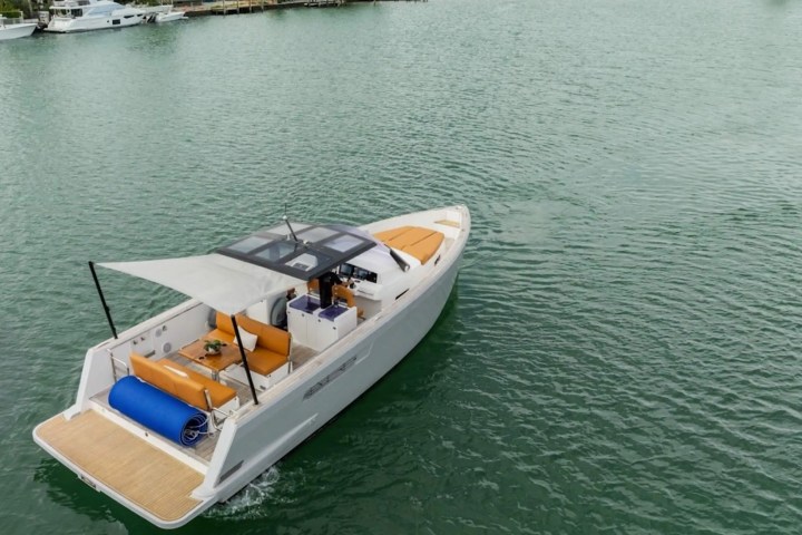 Motorboat with orange seats and a canopy, cruising on a calm body of water