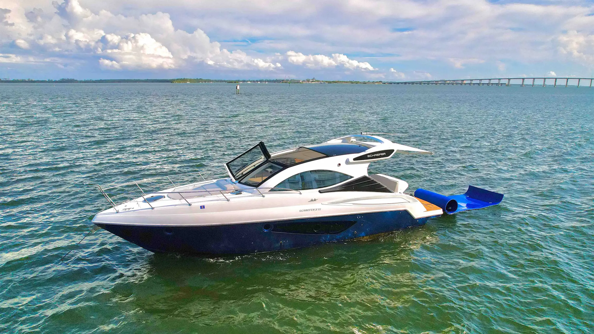 40 Schaefer Boat Rental anchored on Biscayne Bay in Miami featuring a floating water mat, sleek express cruiser profile, and panoramic South Florida waterfront views.