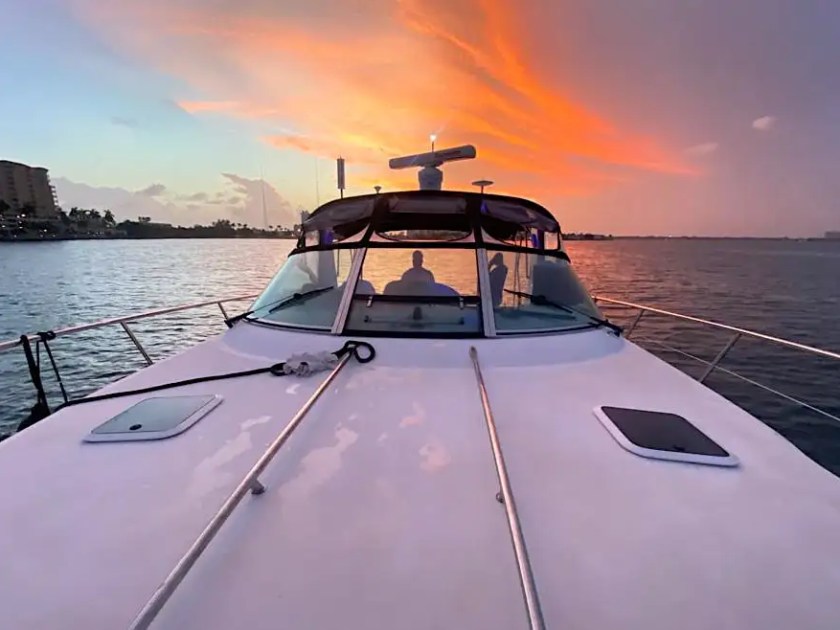 42 SeaRay Boat Rental bow view at sunset in Miami with vibrant orange sky, calm coastal waters, and luxury cruising near Miami Beach, North Bay Village, and Biscayne Bay.
