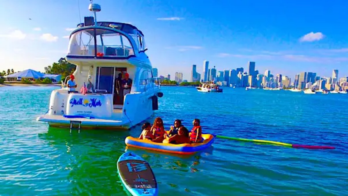 45 Meridian Boat Rental cruising across turquoise waters near Sunny Isles Beach and Haulover Inlet, showcasing the sleek blue hull, enclosed hardtop, and luxury Miami boating experience.