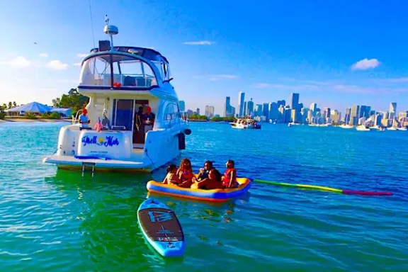 Guests riding water toys behind 45′ Meridian Miami